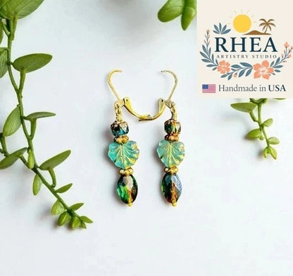 Rhea Artistry Studio handmade Czech glass drop earrings with green leaf beads and antique brass hardware.