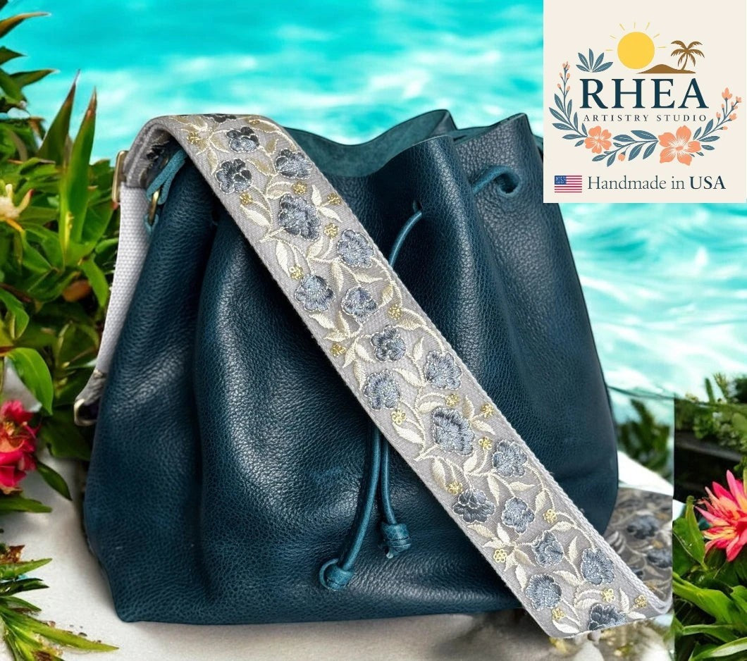 Rhea Artistry Studio dusty blue floral embroidered 2-inch crossbody bag strap with brushed brass hardware.