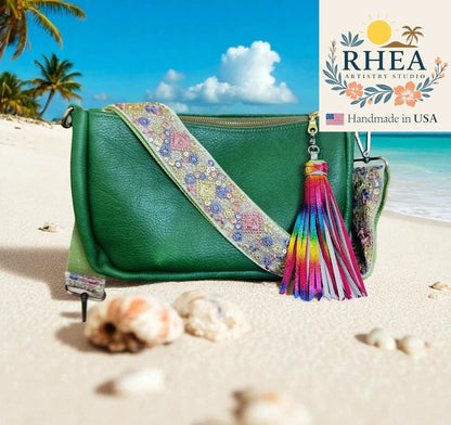 Rhea Artistry Studio green leather crossbody bag with a 2-inch wide embroidered strap featuring jewel tones and a rainbow tassel.