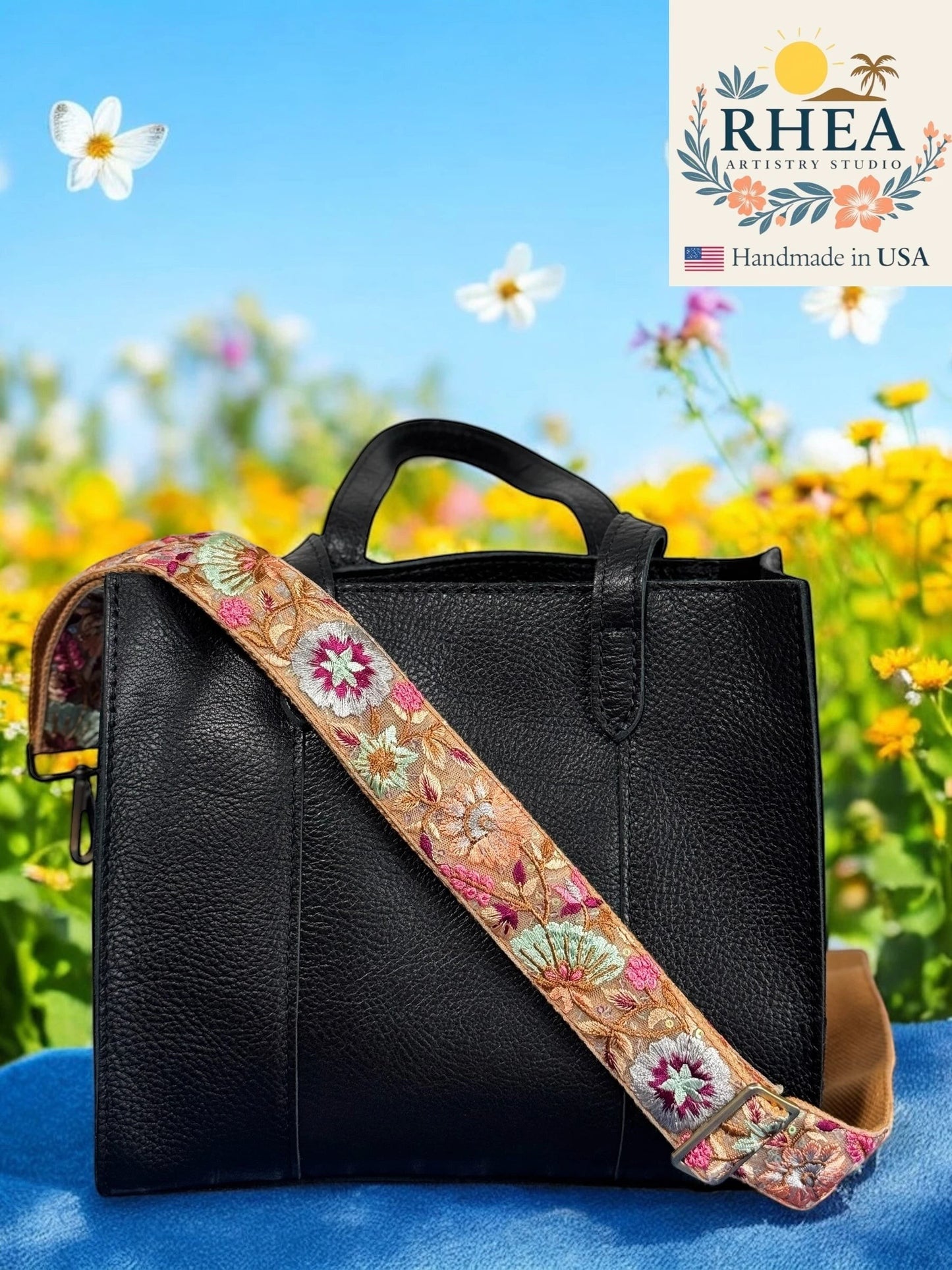 Rhea Artistry Studio 1.5-inch crossbody strap with golden floral embroidery on beige fabric, adjustable length, and brushed brass hardware.