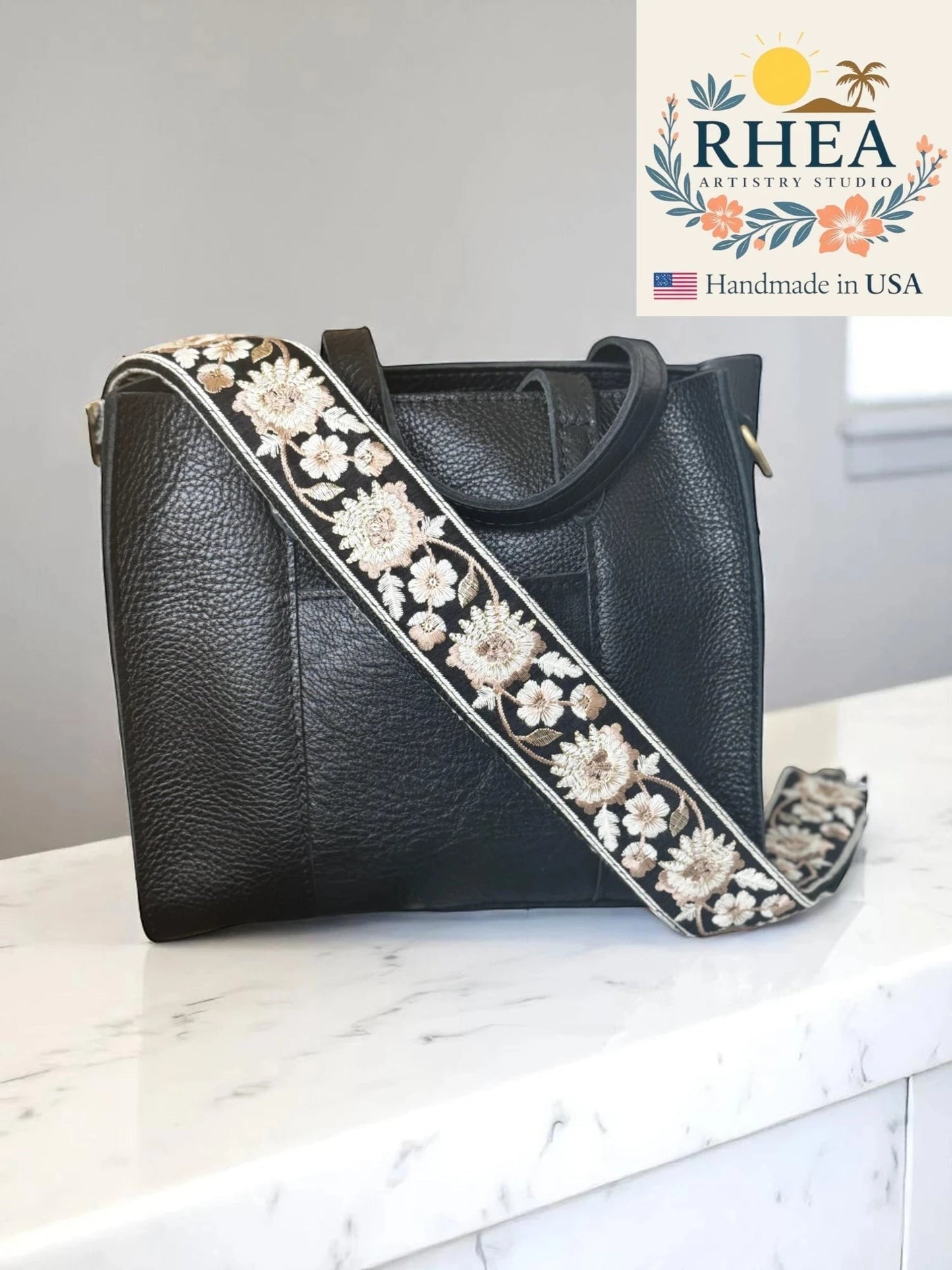 Rhea Artistry Studio black crossbody bag with a 2-inch wide adjustable strap featuring heirloom embroidery in floral patterns.