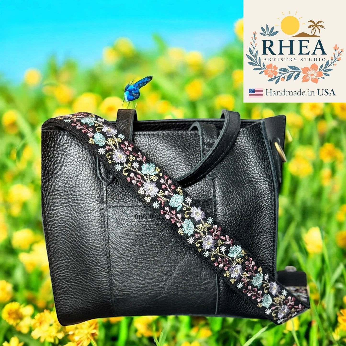 Rhea Artistry Studio black crossbody strap with floral embroidery in pastel colors, adjustable length, brushed brass hardware.