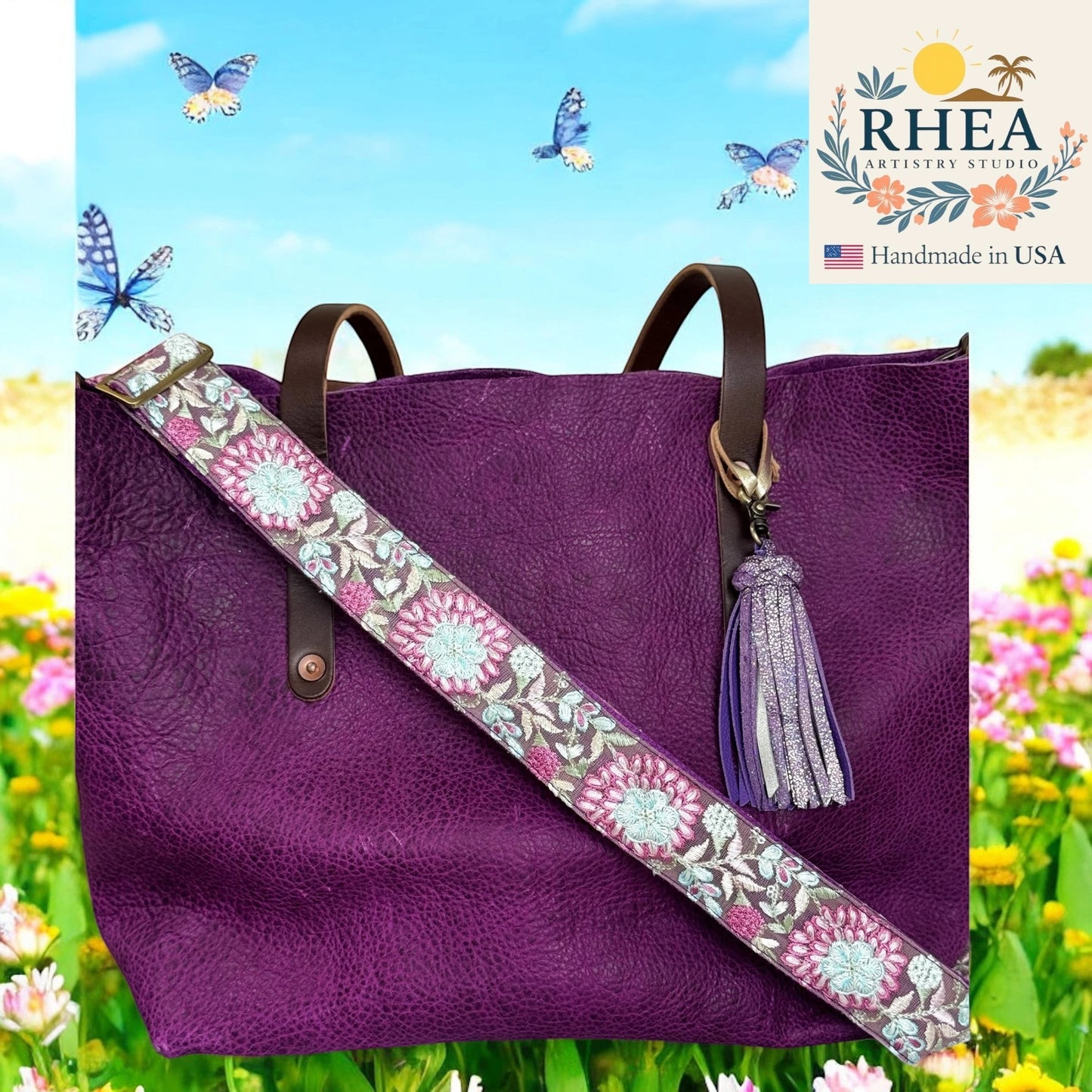 Rhea Artistry Studio purple crossbody strap with frosted pink and silver floral embroidery, adjustable length, brushed brass hardware.