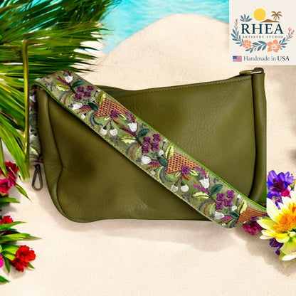 Rhea Artistry Studio green leather crossbody bag with a 2-inch wide embroidered strap featuring floral and wheat designs.