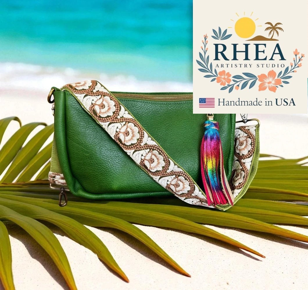 Rhea Artistry Studio green leather crossbody bag with a 2-inch wide embroidered strap featuring floral patterns and a rainbow tassel.