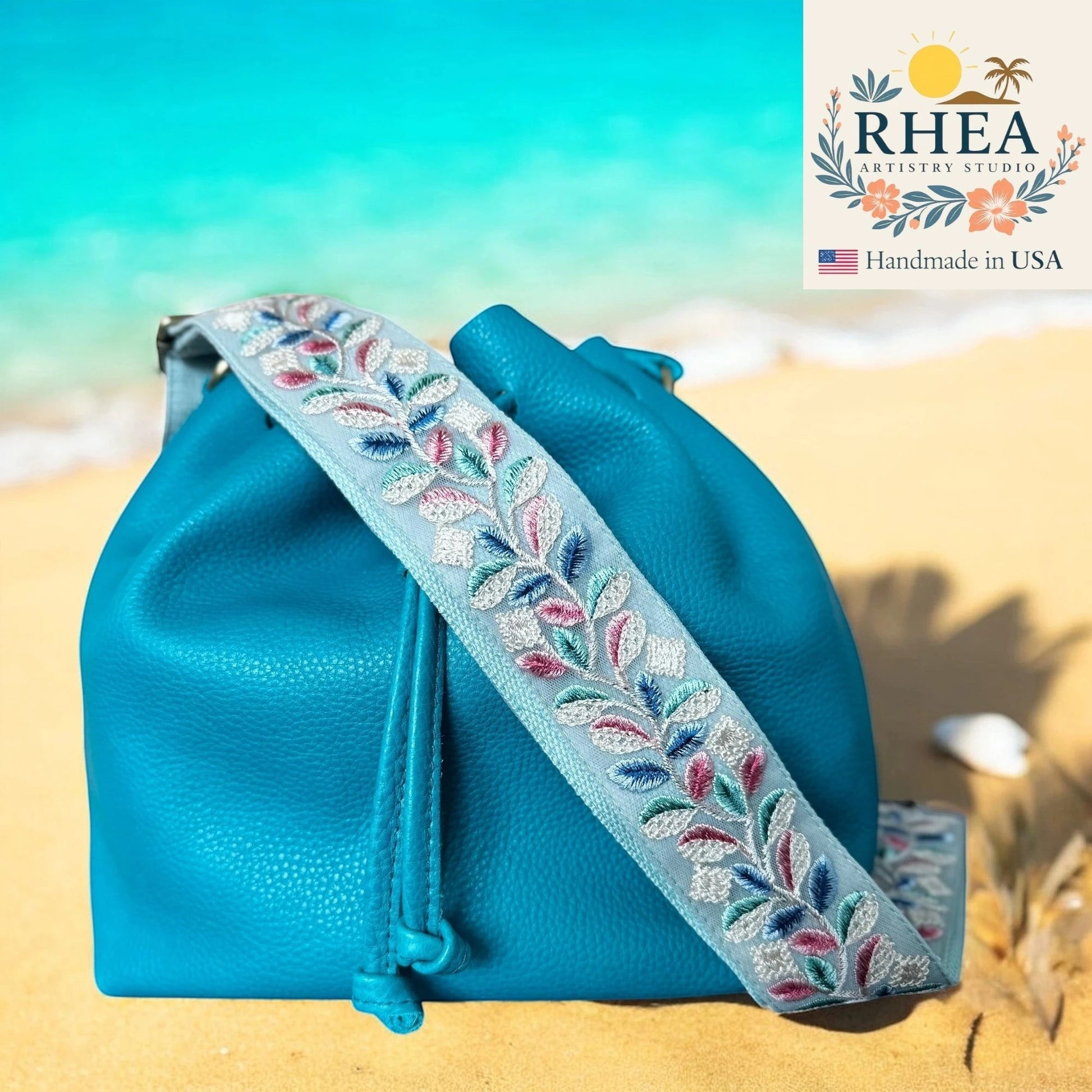 Rhea Artistry Studio light blue embroidered crossbody strap with floral vine pattern, 2-inch wide, adjustable.