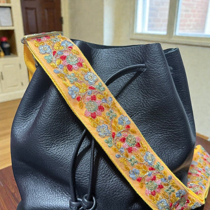Rhea Artistry Studio 2-inch adjustable crossbody strap with vibrant floral embroidery on a yellow lace ribbon, backed with cotton webbing.