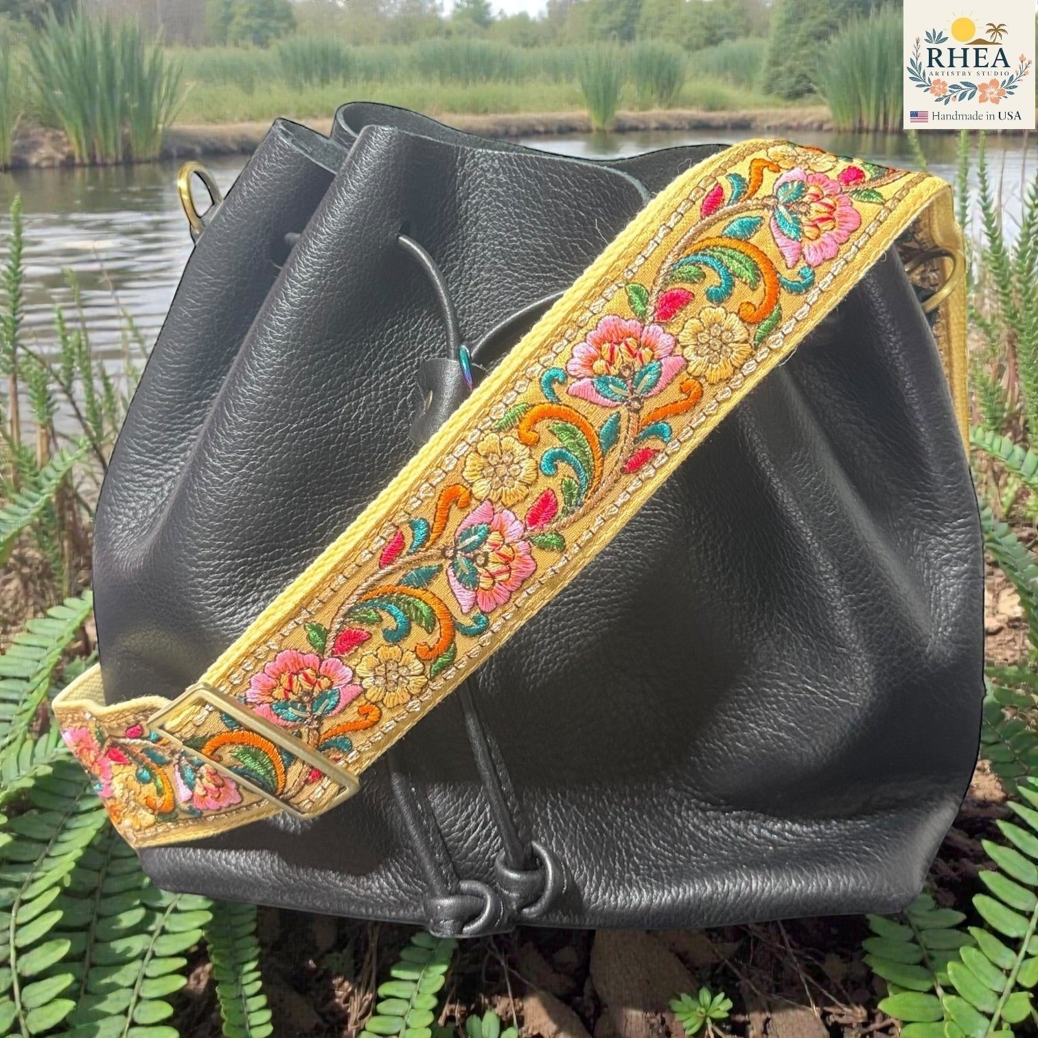 Rhea Artistry Studio 2-inch wide crossbody strap with vibrant floral embroidery on yellow lace, backed with cotton webbing and brass hardware.