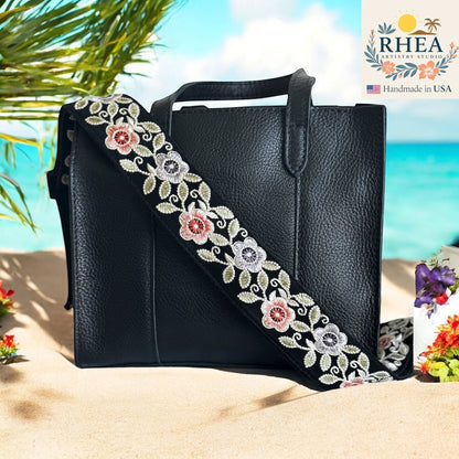 Rhea Artistry Studio black crossbody strap with embroidered colorful florals and leaves, 2-inch wide, adjustable length.