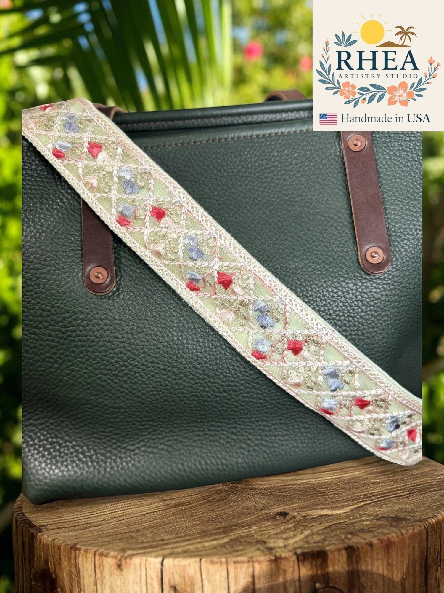 Rhea Artistry Studio light green crossbody strap with embroidered floral details in red and blue, 2-inch width, cotton backing.