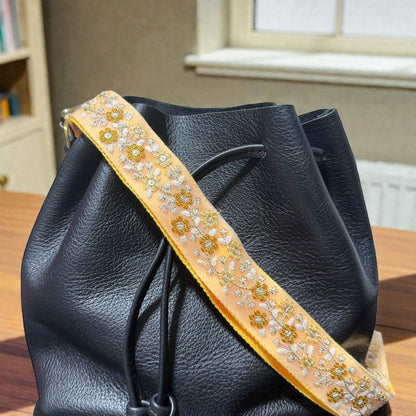 Rhea Artistry Studio peach embroidered floral crossbody strap with brushed brass hardware, 1.5-inch width.
