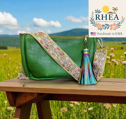 Rhea Artistry Studio green crossbody bag with a 2-inch wide adjustable embroidered floral lace strap and a colorful tassel.