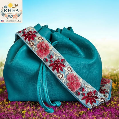 Rhea Artistry Studio blue crossbody strap with red and white floral embroidery, 2-inch width, adjustable length.