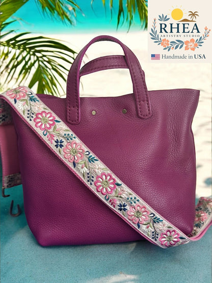Rhea Artistry Studio 1.5-inch crossbody strap with embroidered pink and blue pinwheel flowers on a light grey background, adjustable length.