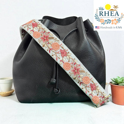 Rhea Artistry Studio 2-inch crossbody strap with light blue lace embroidered with pink and coral flowers and leaves. Adjustable.