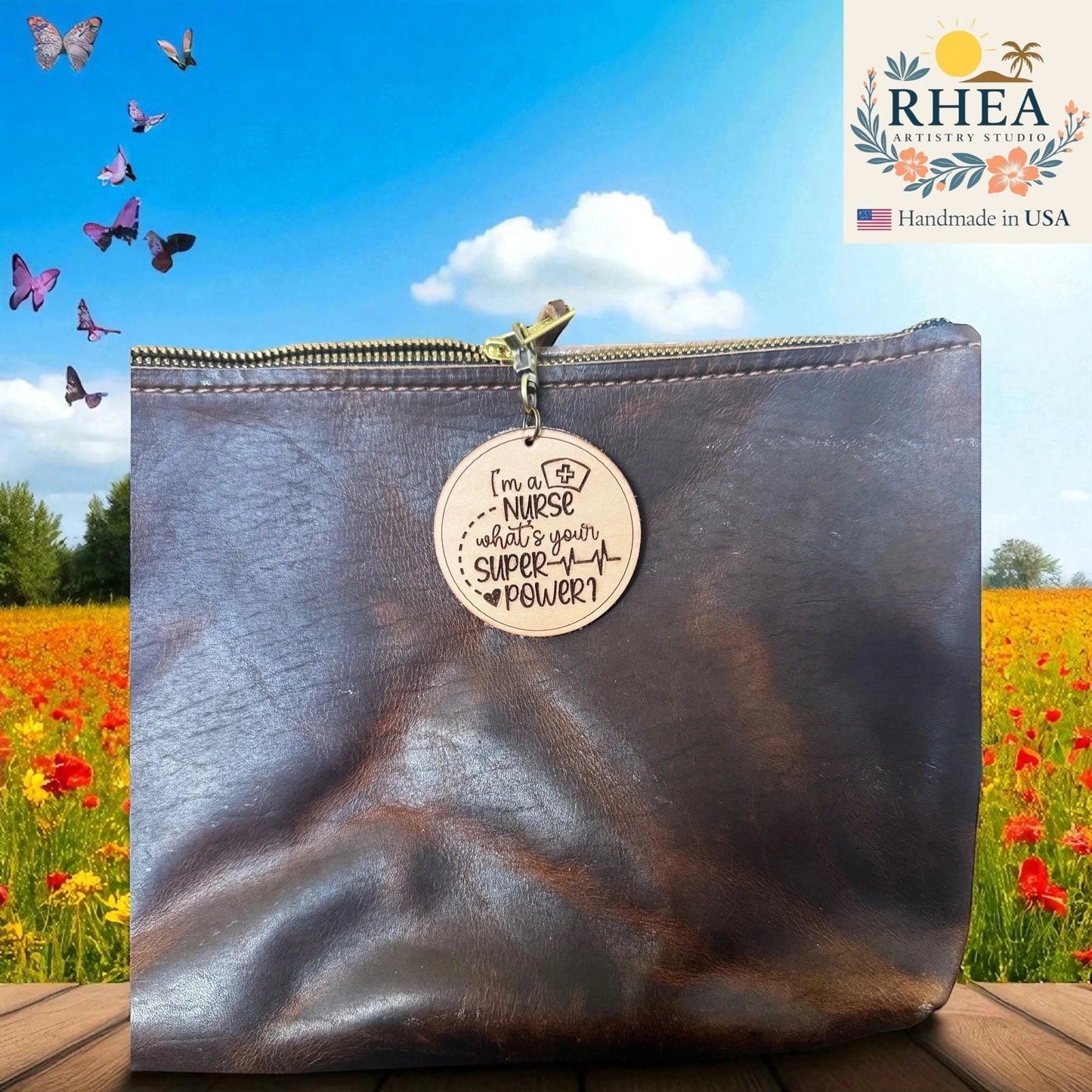 Rhea Artistry Studio light brown leather tag engraved with "I'm a NURSE what's your SUPER POWER?" attached to a dark brown leather bag.