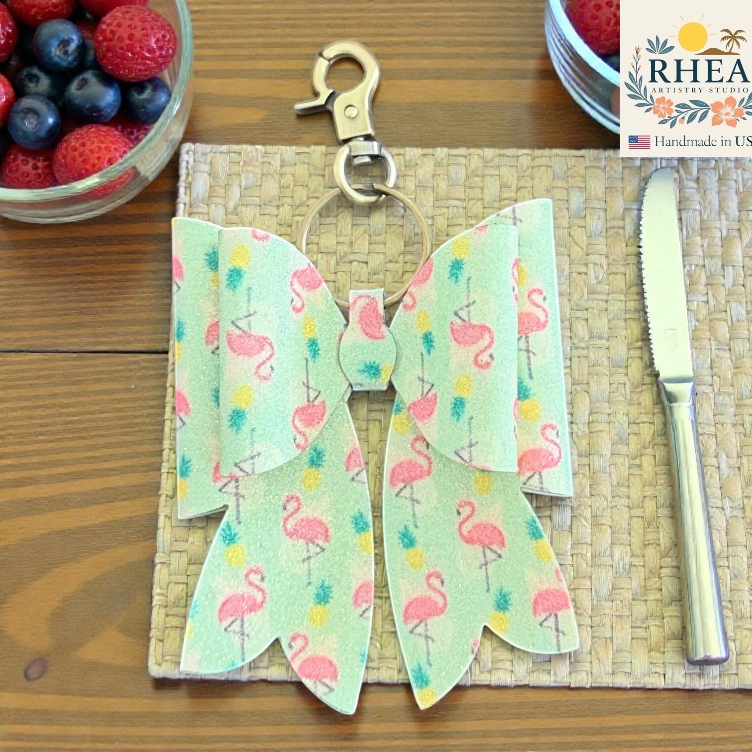 Rhea Artistry Studio handmade light green double-layer bow charm with pink flamingos and pineapples, brass hardware.