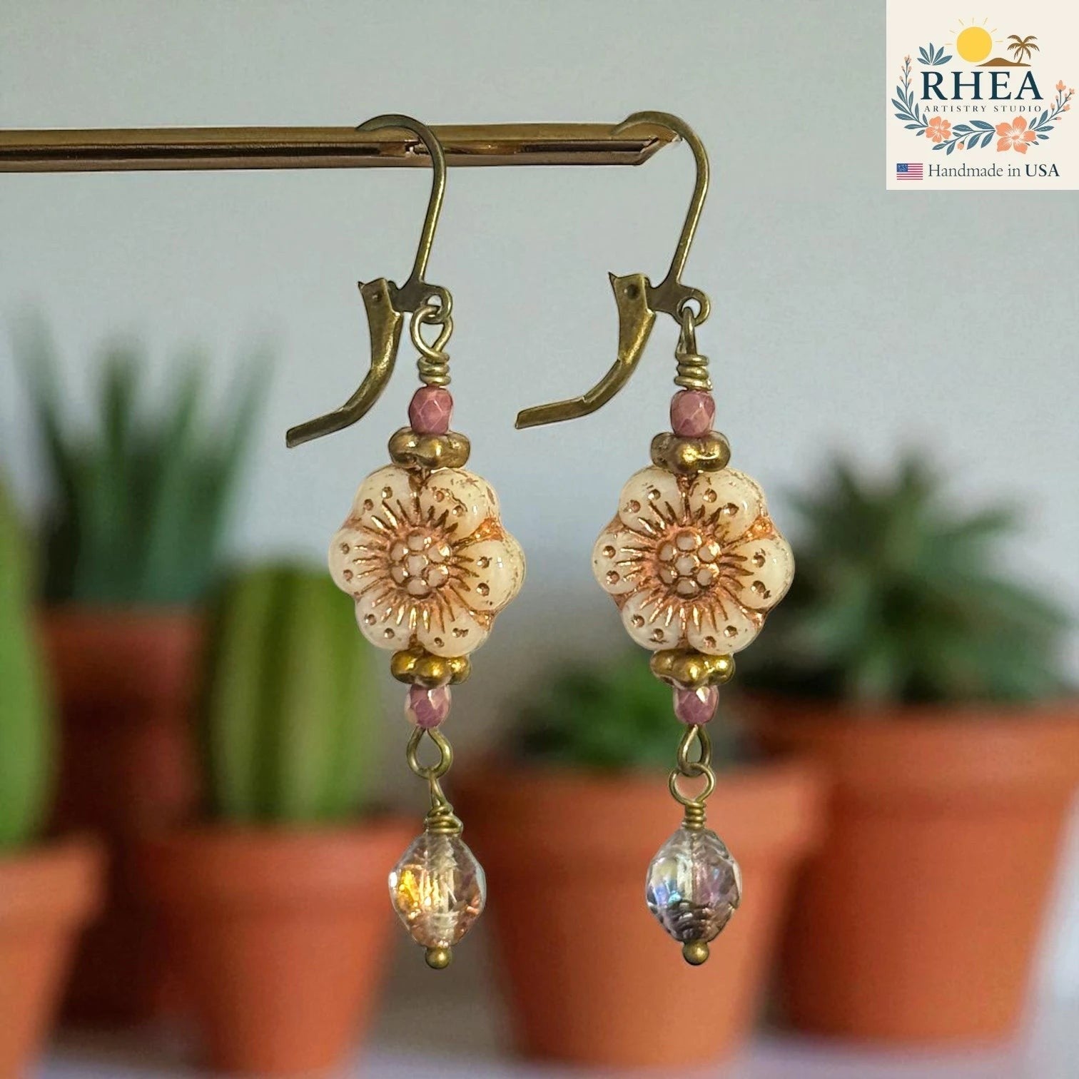 Rhea Artistry Studio cream floral Czech glass bead dangle earrings with rose gold accents and crystal drops, antique brass hooks.