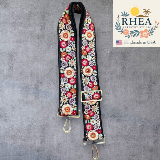 Rhea Artistry Studio black strap with colorful floral embroidery, 2-inch wide, adjustable, with brushed brass hardware.