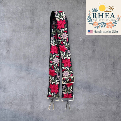 Rhea Artistry Studio black crossbody strap with vibrant red and pink floral embroidery, 1.5-inch width, adjustable length, and brushed brass hardware.