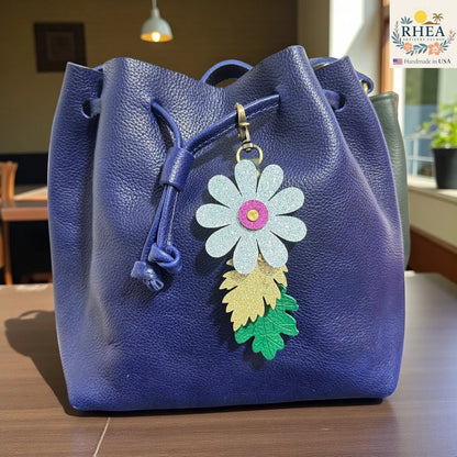 Rhea Artistry Studio glitter flower and embossed leaf leather purse charm with antique brass clasp.