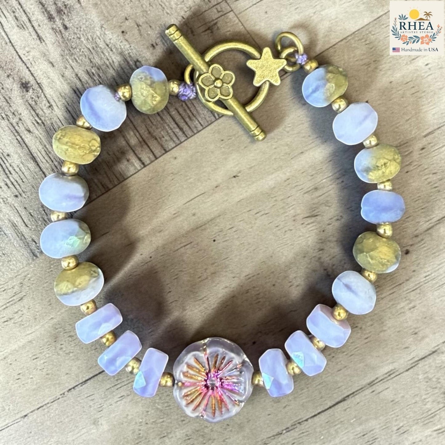 Rhea Artistry Studio handmade garden glass bead bracelet with lilac, peach, and gold beads, and a floral focal element.