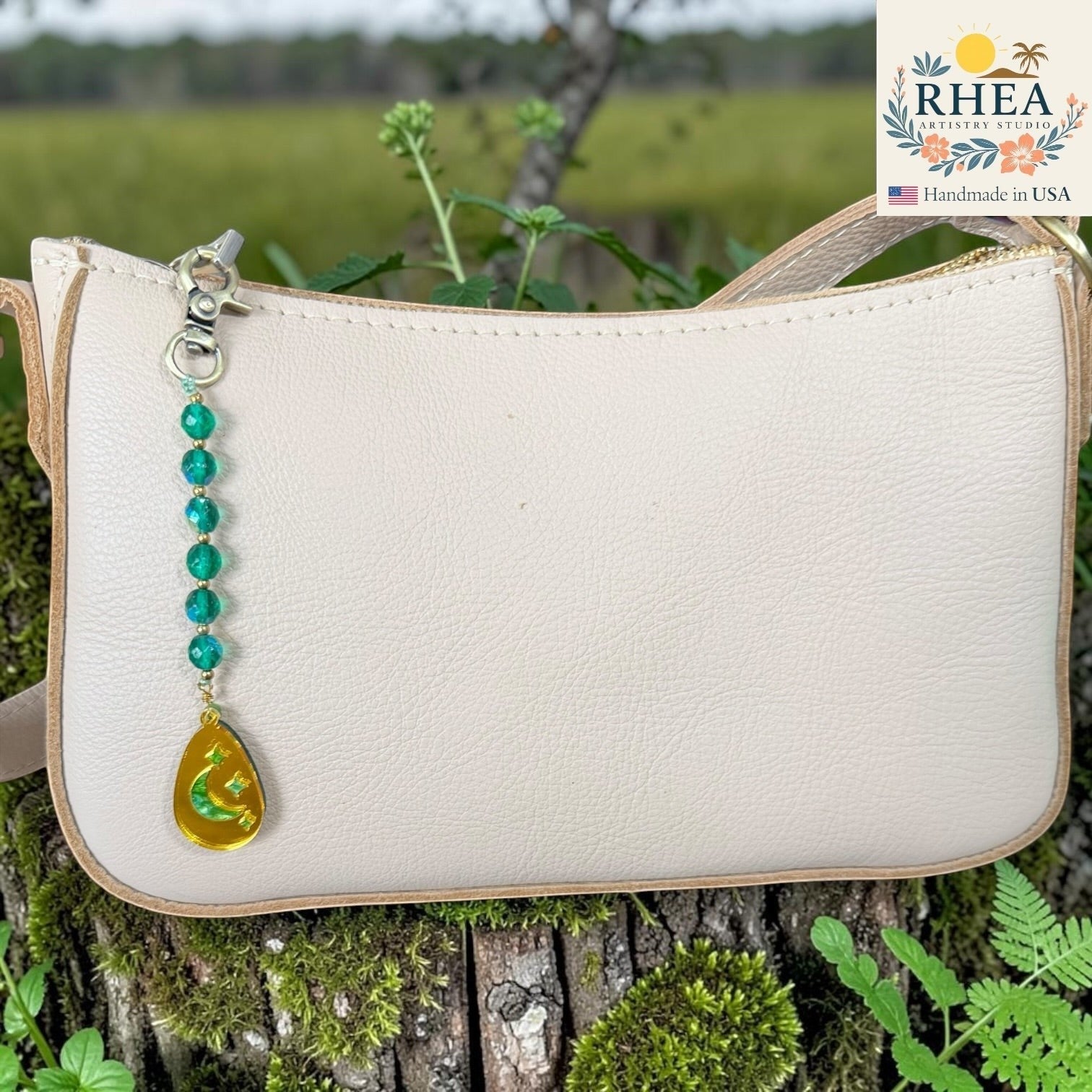 Rhea Artistry Studio bag charm with green faceted glass beads and a gold pendant featuring a crescent moon and stars.