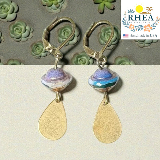 Rhea Artistry Studio handcrafted drop earrings with faceted glass beads and brushed brass teardrops. Available in Burnished Amber and Neptune Mist.