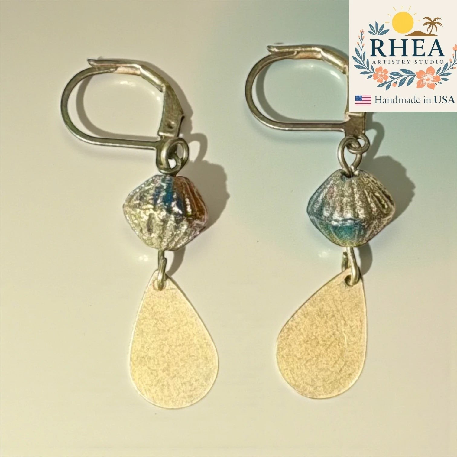 Rhea Artistry Studio handcrafted drop earrings with faceted glass beads and brushed brass teardrop charms, approx. 2 inches long.