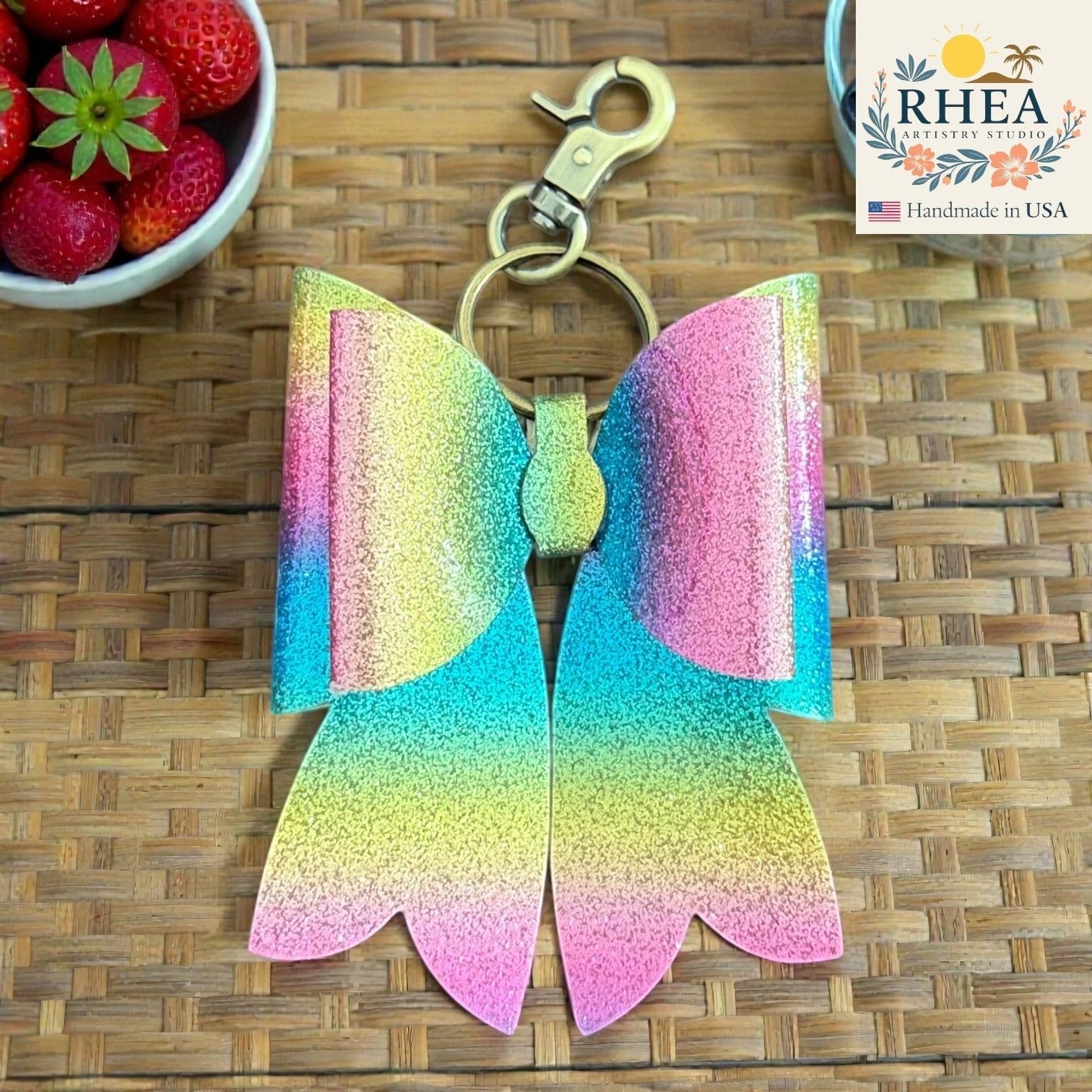 Rhea Artistry Studio handmade glitter rainbow double layer French bow bag charm with brass hardware.