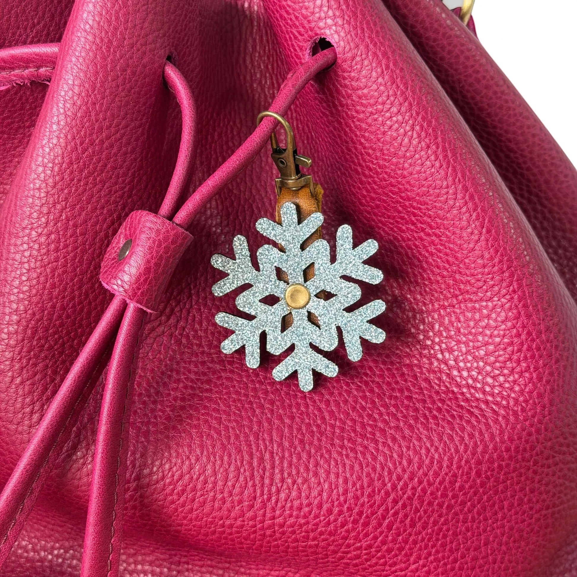 Rhea Artistry Studio glitter snowflake leather charm with brass hardware, perfect for bags and keychains.