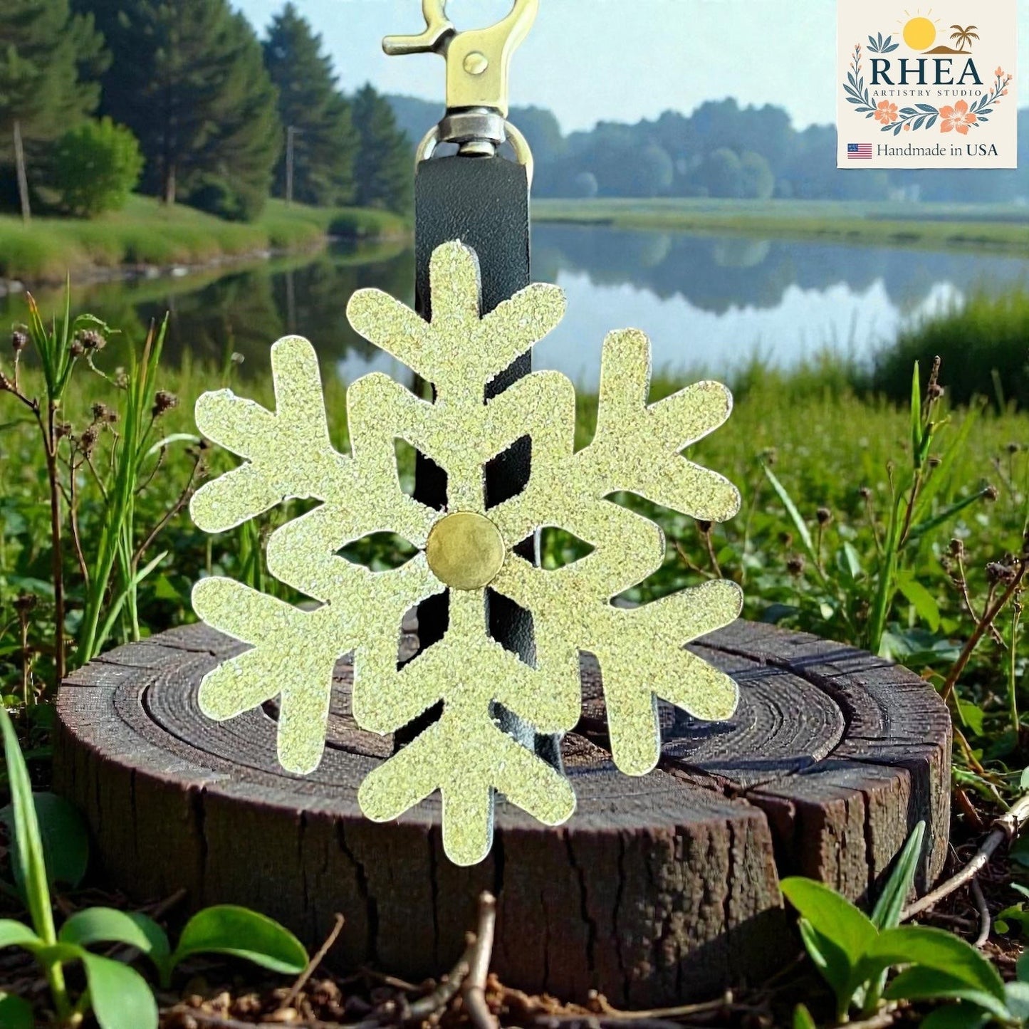Rhea Artistry Studio glitter snowflake mini charm, handmade from glitter leather with a brass accent, perfect for bags and keychains.