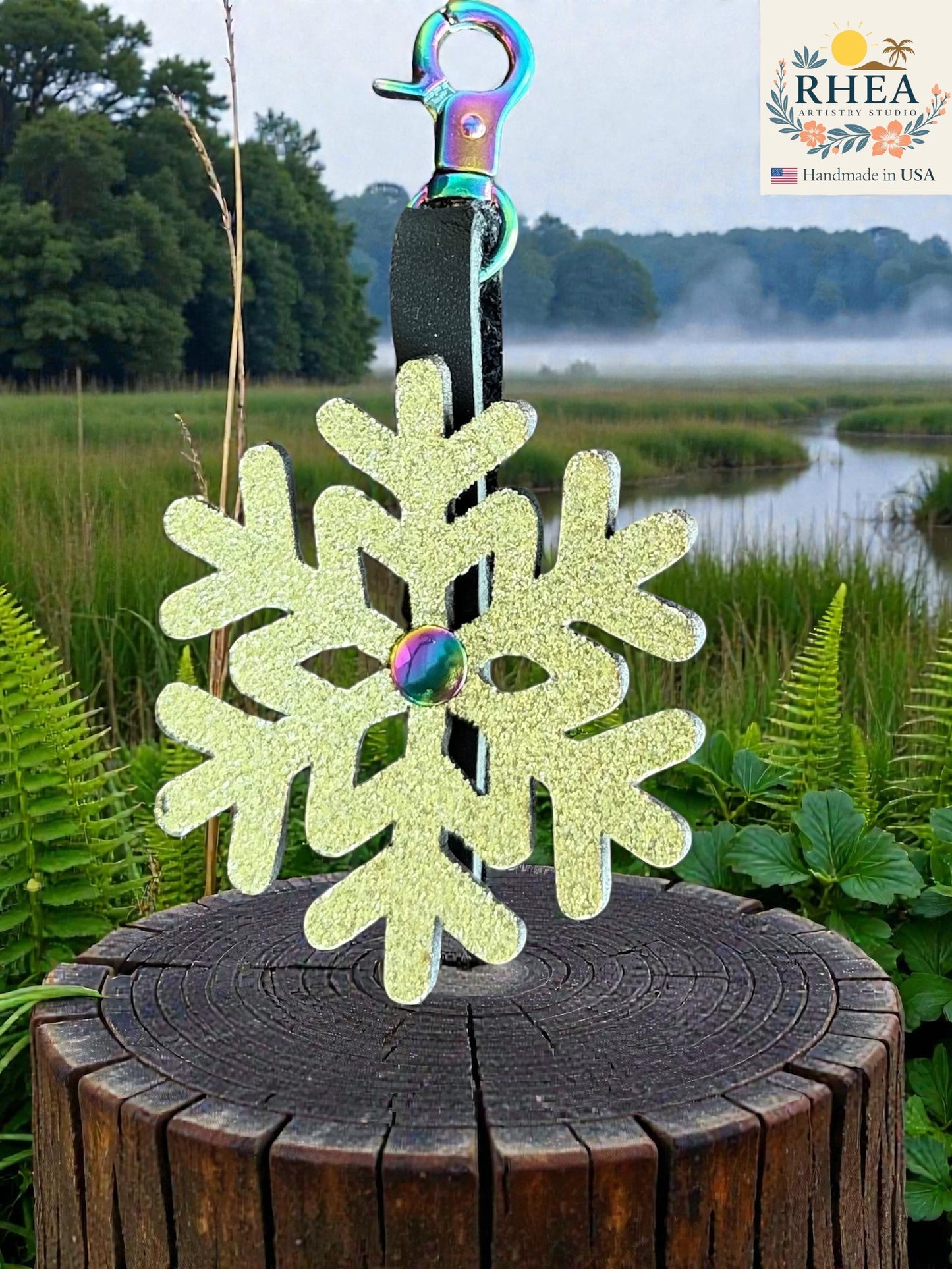 Rhea Artistry Studio light yellow glitter snowflake leather charm with rainbow clasp, handmade in USA.