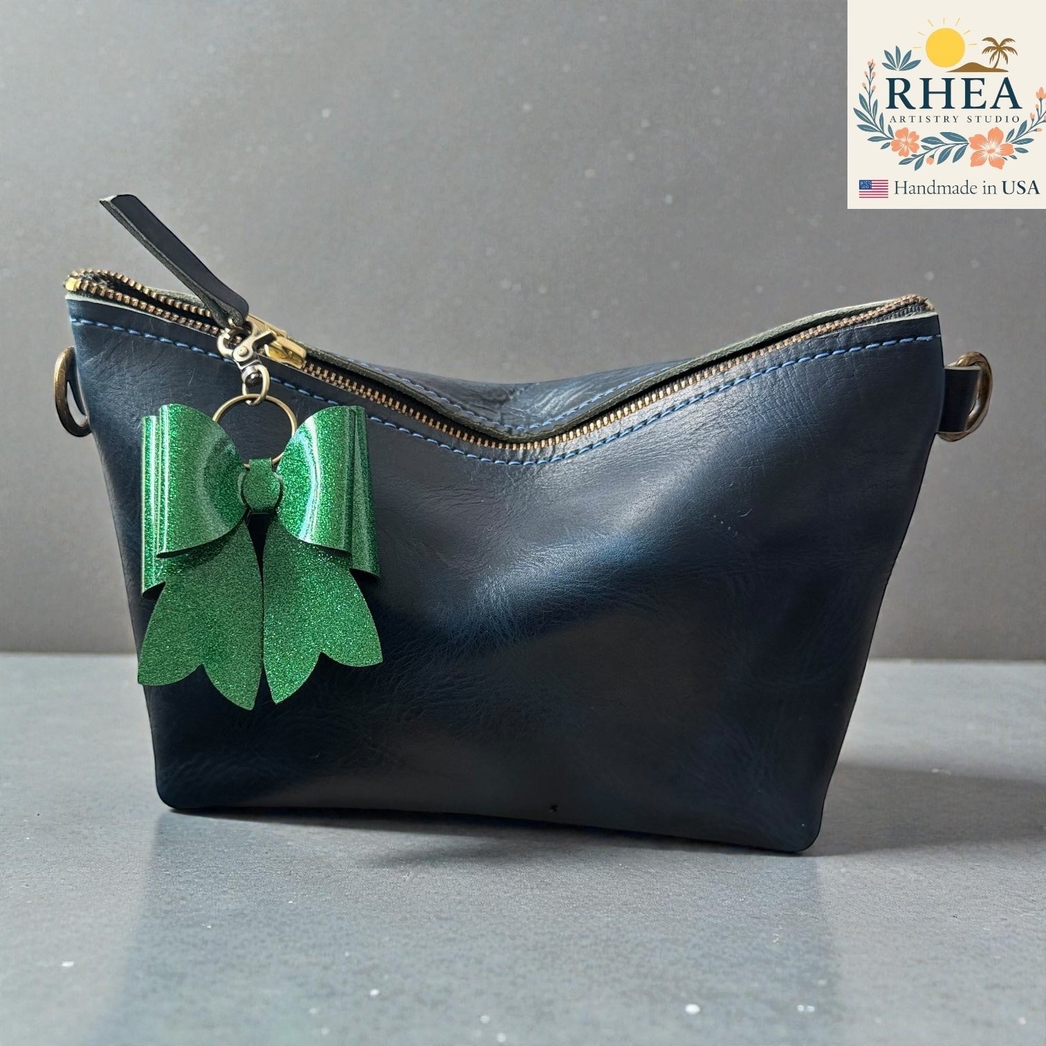 Rhea Artistry Studio handmade green glitter double-layer French bow bag charm with brass hardware.