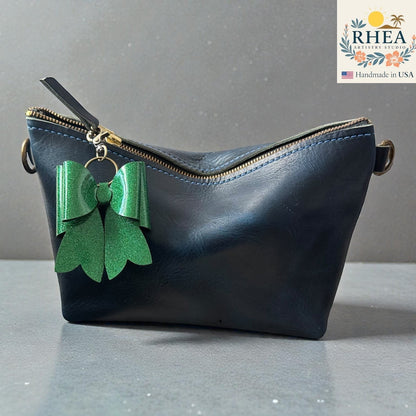 Rhea Artistry Studio handmade green glitter double-layer French bow bag charm with brass hardware.