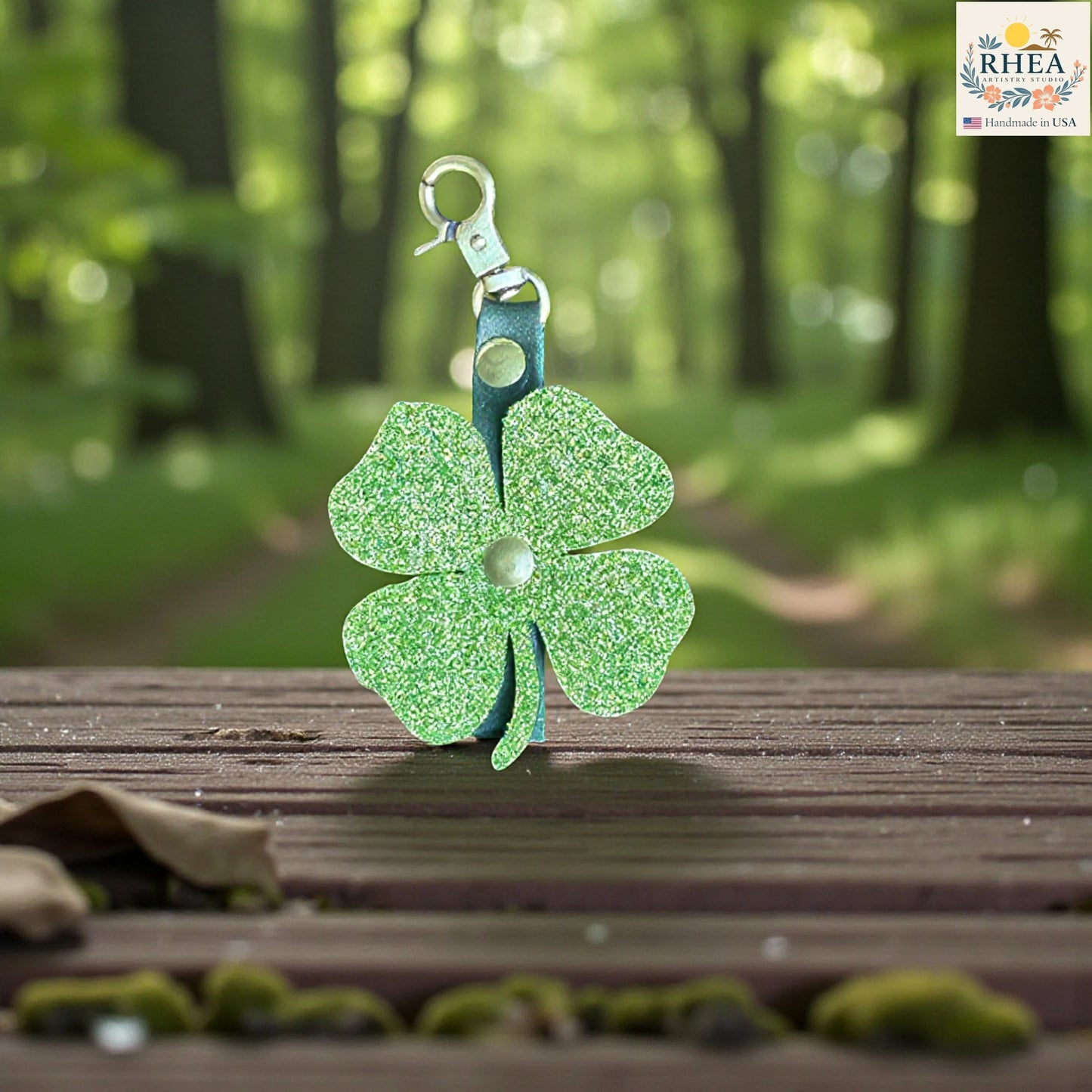 Rhea Artistry Studio green glitter leather four-leaf clover charm with brass hardware, perfect for bags and keychains.