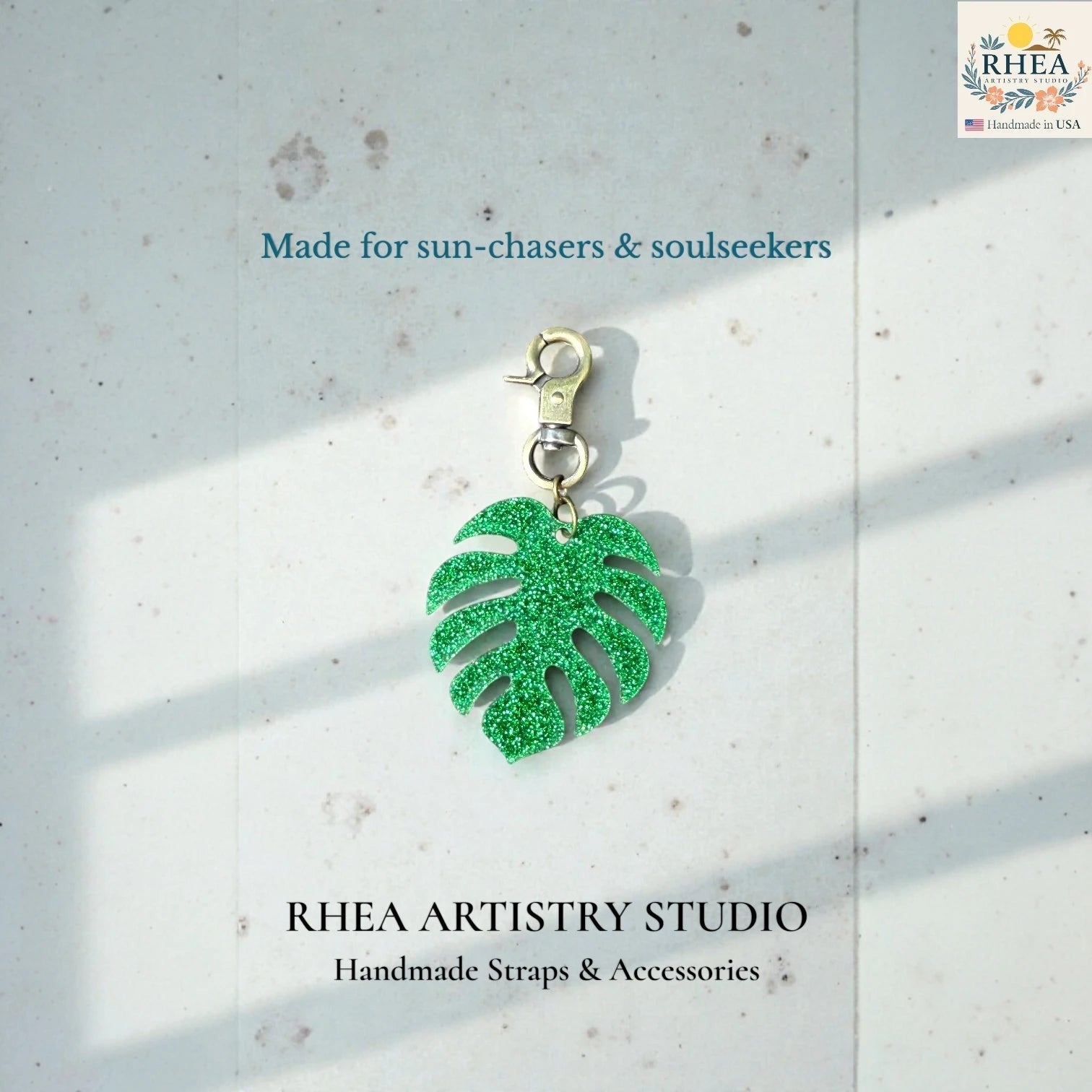 Rhea Artistry Studio green glitter monstera leaf acrylic charm with antique brass clasp, perfect for bags or keys.