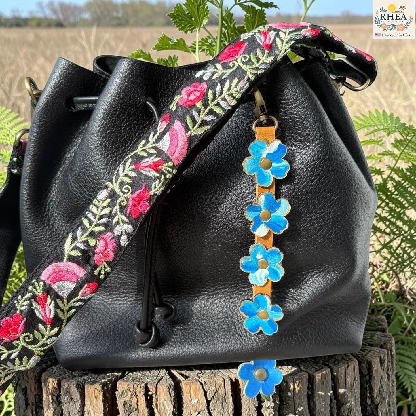 Rhea Artistry Studio Hand-Painted Leather Flower Bag Charm featuring organic painted leather flowers, brass rivets, honey leather strap, and antique brass clasp.