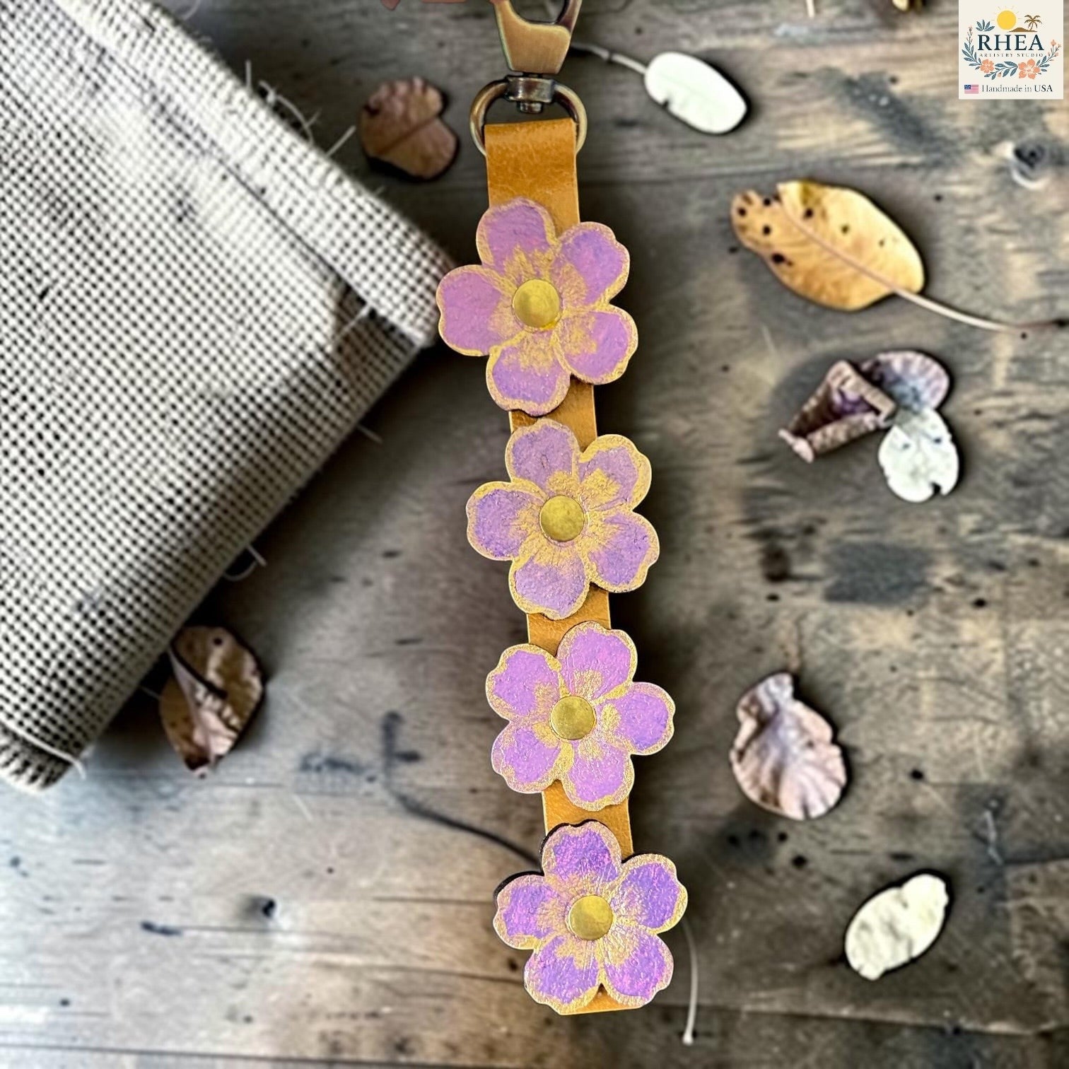 Rhea Artistry Studio Hand-Painted Leather Flower Bag Charm in Lavender Honey with sealed painted floral leather charms, brass rivets, and honey leather strap.