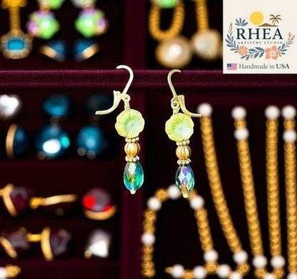 Rhea Artistry Studio light green floral hibiscus earrings with iridescent blue-green drop beads and gold accents.