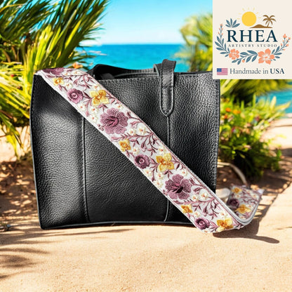 Rhea Artistry Studio 2-inch crossbody strap with purple and yellow hibiscus embroidery on white lace over cotton webbing.