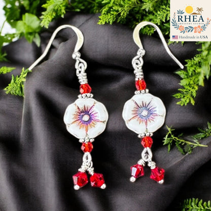 Rhea Artistry Studio white hibiscus floral glass bead earrings with red crystal accents and silver-plated hooks.