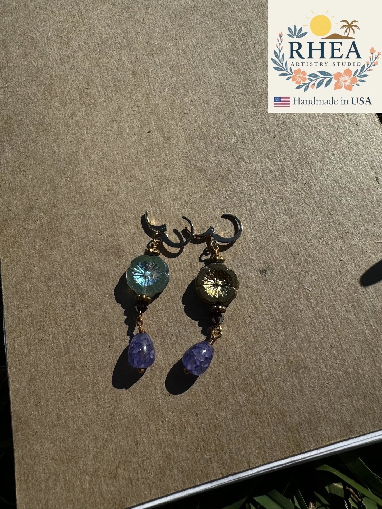 Rhea Artistry Studio hibiscus violet drop earrings with 24k gold plated brass, Czech glass, and amethyst gemstones.