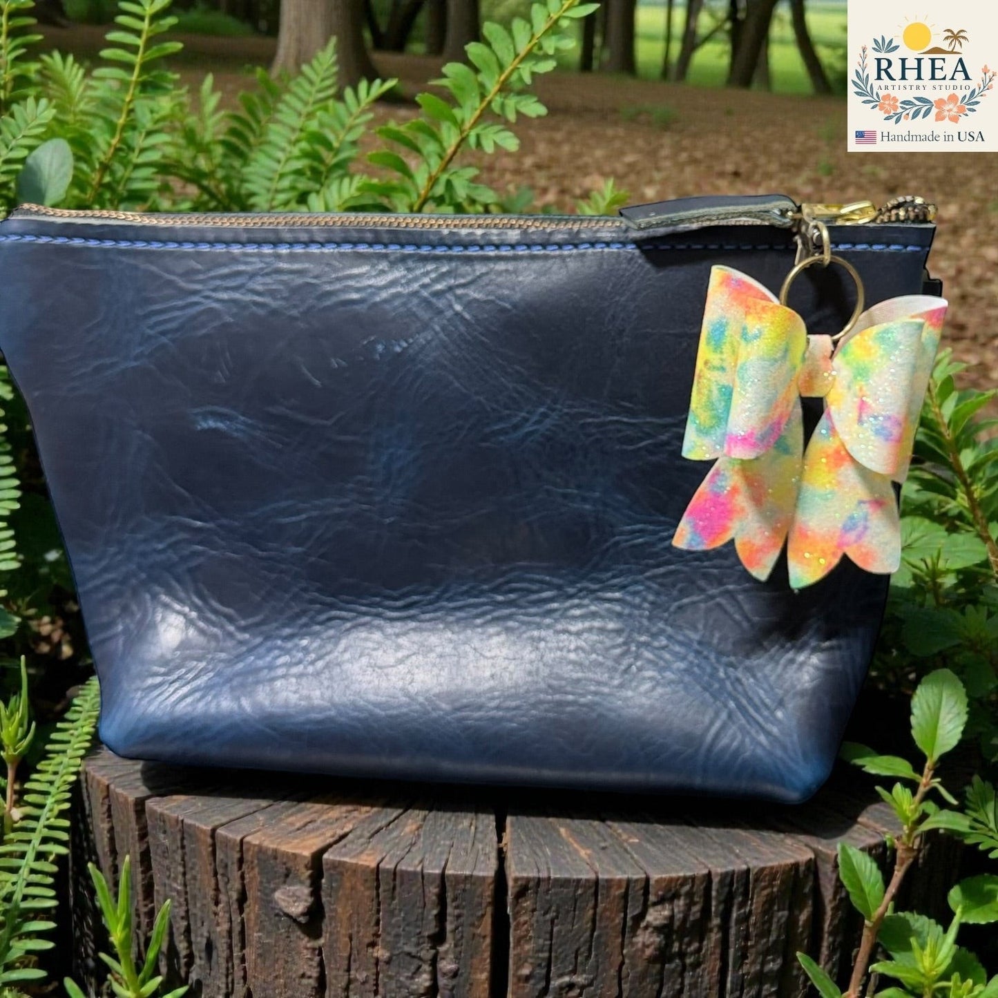 Rhea Artistry Studio handmade double-layer French bow bag charm with holographic tie-dye finish and brass hardware.