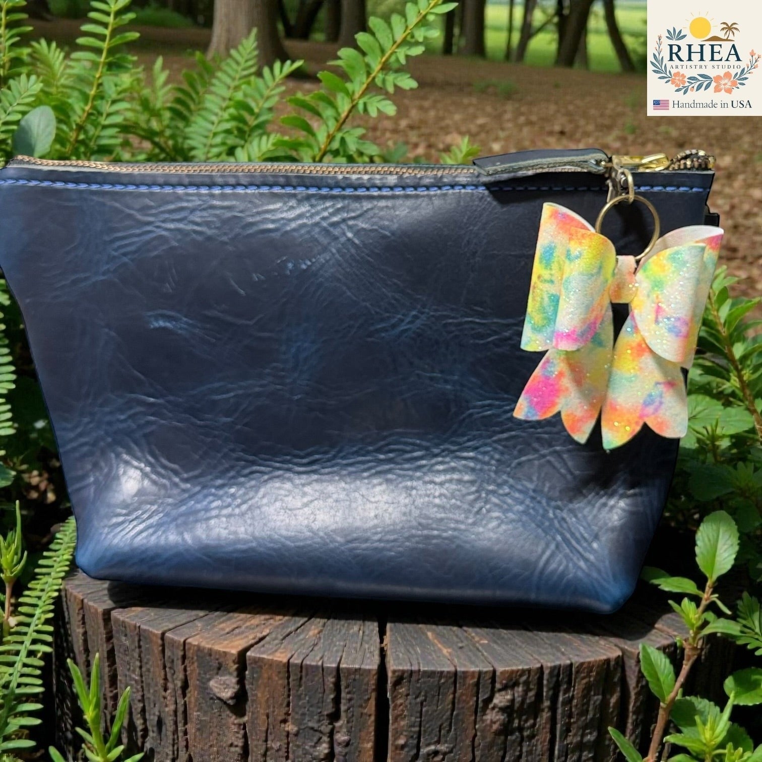 Rhea Artistry Studio handmade double-layer French bow bag charm with holographic tie-dye finish and brass hardware.