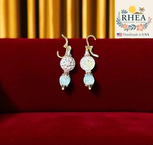 Rhea Artistry Studio icy blue and silver glass dahlia floral drop earrings with brass hardware, approx. 1.5-2 inches long.