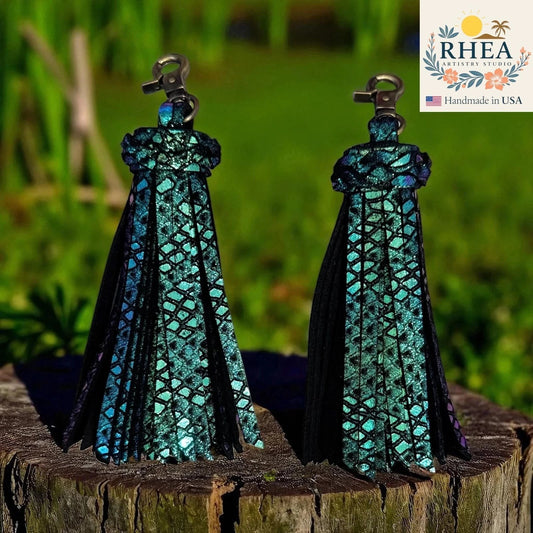 Rhea Artistry Studio handmade iridescent teal leather tassel keychain with antique brass lobster clasp, approx. 5 inches long.