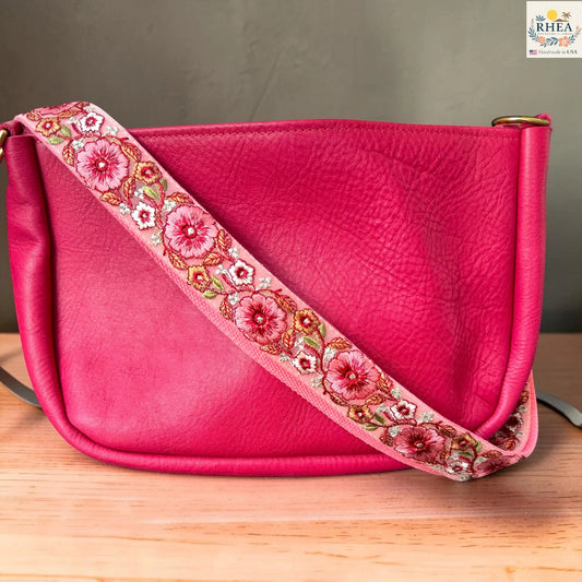 Rhea Artistry Studio ivory crossbody strap with coral and red floral embroidery with green leaf accents, 1.5-inch width, adjustable length.