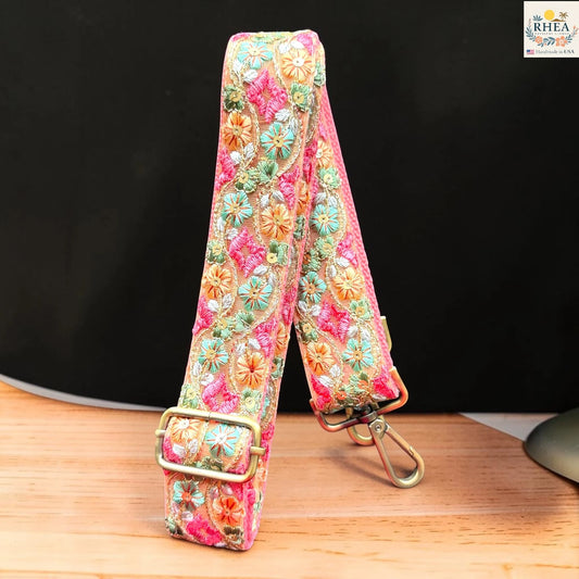 Rhea Artistry Studio ivory crossbody strap with orange, teal, and pink floral embroidery, 1.5-inch width, adjustable length.