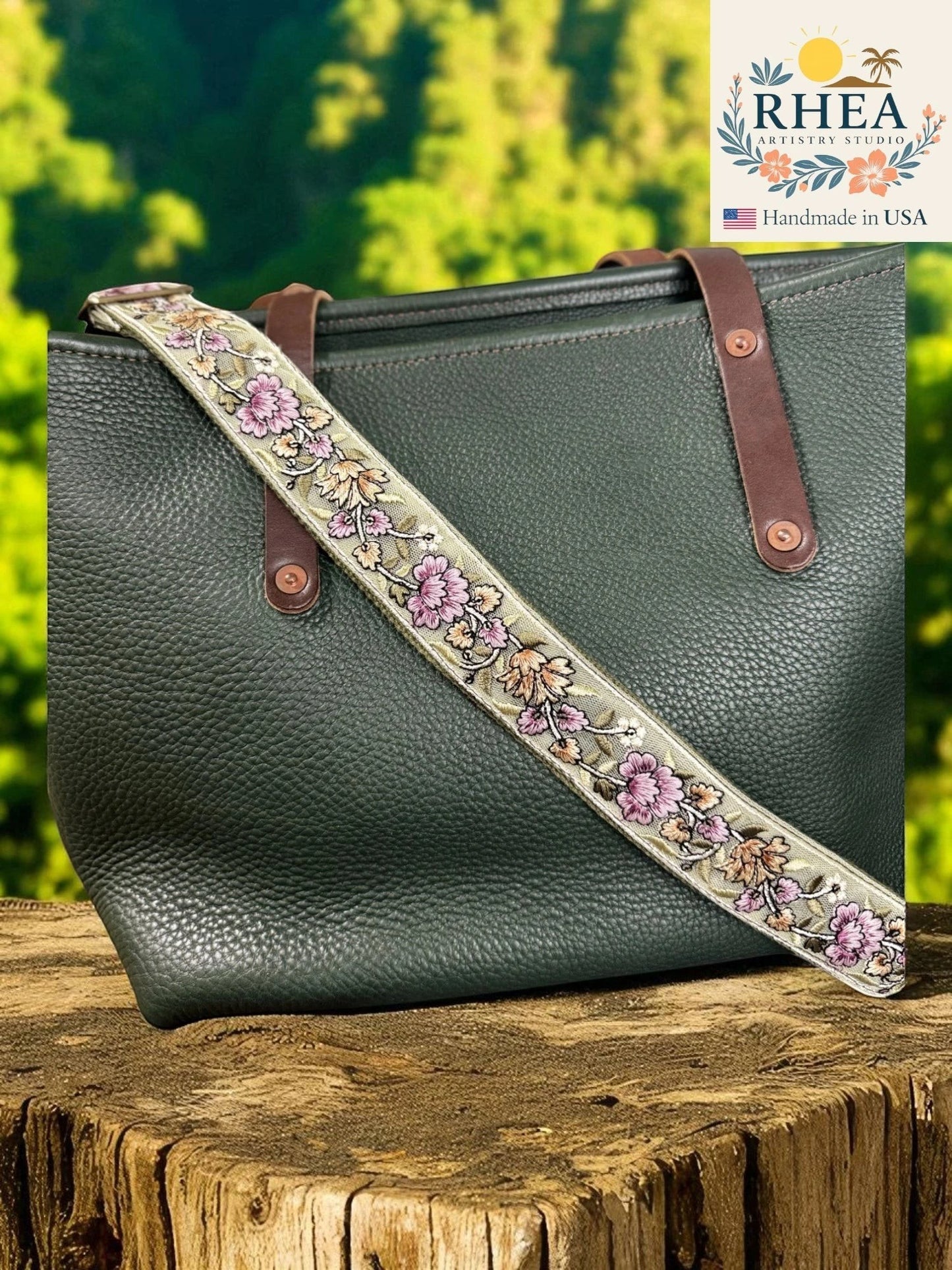 Rhea Artistry Studio lavender and silver embroidered crossbody strap with floral detail on a green pebbled leather tote bag.